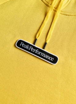 PEAK PERFORMANCE SEASONAL PATCH HOOD MEN Citrine -Ski Uitrusting Verkoop schermafbeelding 2021 10 09 om 16.11.25